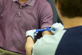 nurse tying rubberband around patient's arm